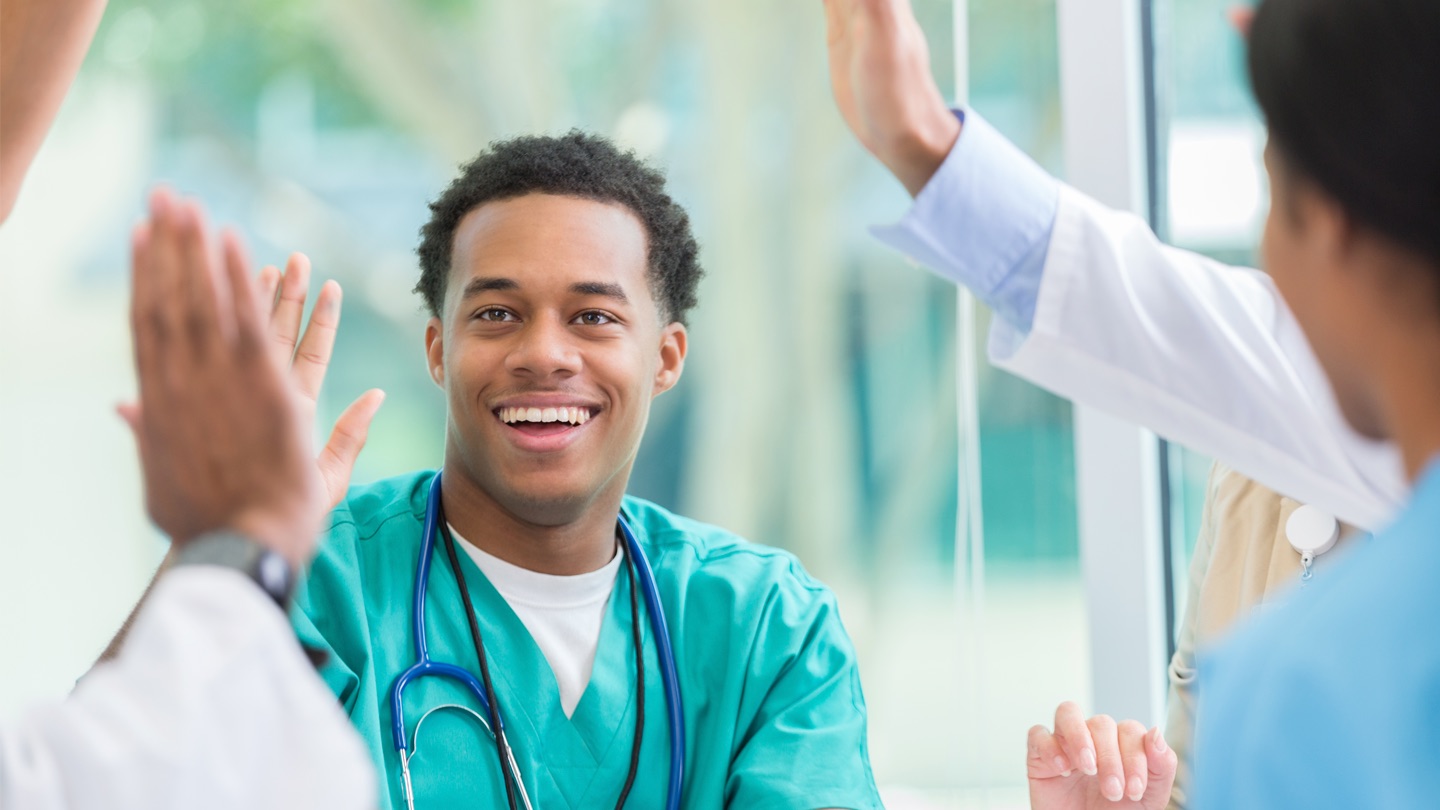 A nurse cheering with his colleagues